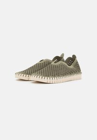 Grønne slip-on sko med en tekstureret, vævet overdel og ventilationshuller. Cremefarvet sål med et rillemønster langs kanten.