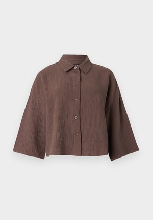 Chemise marron froissée texturée avec boutons, manches larges et col classique sur fond blanc.