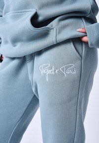 Pantaloni della tuta azzurro chiaro con logo ricamato "Project x Paris". Include tasche laterali e un tessuto morbido e strutturato.
