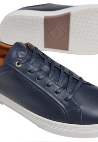 Marina läder sneakers med rund tå, strukturerade snörningar, vit gummisula och subtil märkning på sidan. Slät finish med kontrasterande accenter.