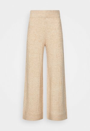 Beige Strickhose mit weitem Bein, Rippbund und Bündchen, mit strukturiertem Zopfmuster.