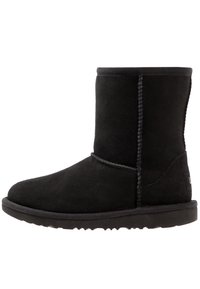 Botas negras de ante hasta el tobillo, con un acabado texturizado, detalles cosidos en las costuras y una suela de goma duradera.