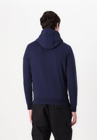 Felpa blu navy con tasca a marsupio, polsini e orlo a costine e cappuccio con cordino, realizzata in morbido materiale misto cotone.