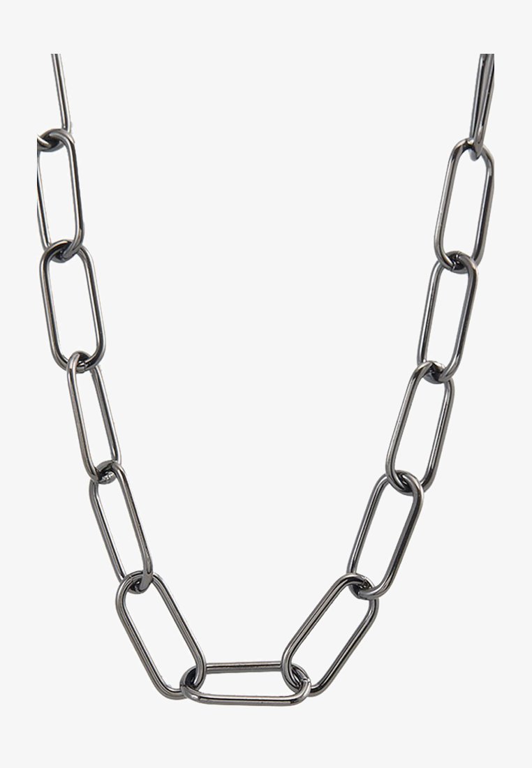 Muzieklink ketting gemaakt van zilverkleurig metaal, met verlengde ovale schakels met een gladde textuur en een uniforme afwerking.