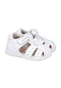Sandalias blancas con diseño perforado, correas de Velcro ajustables, suelas de goma y un interior acolchado. Material ligero para mayor comodidad.