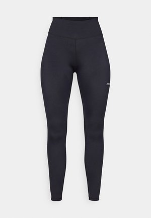 High-waisted black leggings made of stretch fabric, featuring a smooth texture and a small logo on the lower leg. Form-fitting design.
