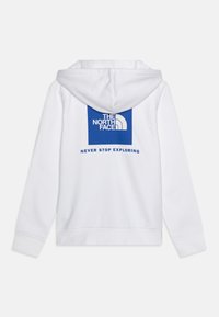 Felpa bianca con cappuccio e logo stampato blu sul retro. Il testo recita "THE NORTH FACE" e "NEVER STOP EXPLORING" sotto il logo.