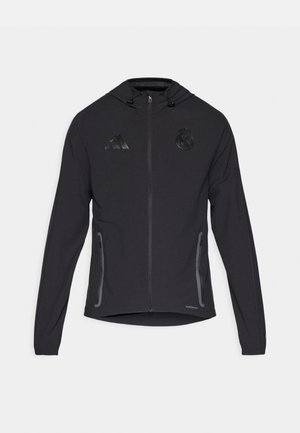 Zwarte sport Jack met een ritssluiting aan de voorkant, een trekkoord capuchon, zijzakken en getextureerde logo-accenten. Gemaakt van lichtgewicht stof.