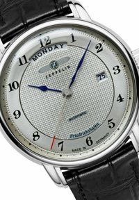 Silver watch face with a textured pattern, black leather strap, blue hour and minute hands, day and date display, and stainless steel case.