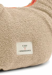 Borsa beige morbida con tessuto texturizzato, dotata di una cerniera arancione e di un'etichetta con il logo "UNIO HAMBURG X LES VISIONNAIRES."