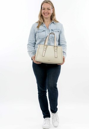 Beige strukturierte Handtasche mit doppelten Griffen und goldenen Hardware-Akzenten. Glatte Textur, rechteckige Form und minimalistisches Design.