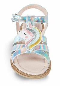 Holografinen synteettinen sandaali, jossa on useita hihnoja, vaaleanpunainen pehmeä pohja ja yksisarvisapplikaatio pasteliväreissä. Säädettävä solki.