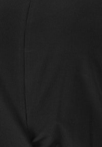 Svart ribbat tyg med en mjuk textur, med vertikala ränder och en slät yta, lämpligt för olika klädapplikationer.