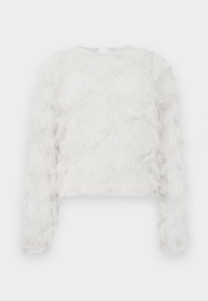 White cropped long-sleeve top featuring textured fringes, a round neckline, and a concealed back zipper. Soft fabric with layered design.