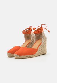 Espadrillas a zeppa in suede arancione con cinturino alla caviglia in tessuto beige testurizzato e lacci coordinati. Suola in juta intrecciata confortevole. Design con punta quadrata.