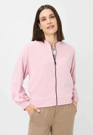 Lichtroze ritsjack met een hoge halslijn, drop shoulders en geribbelde manchetten. Glad materiaal met minimale details.