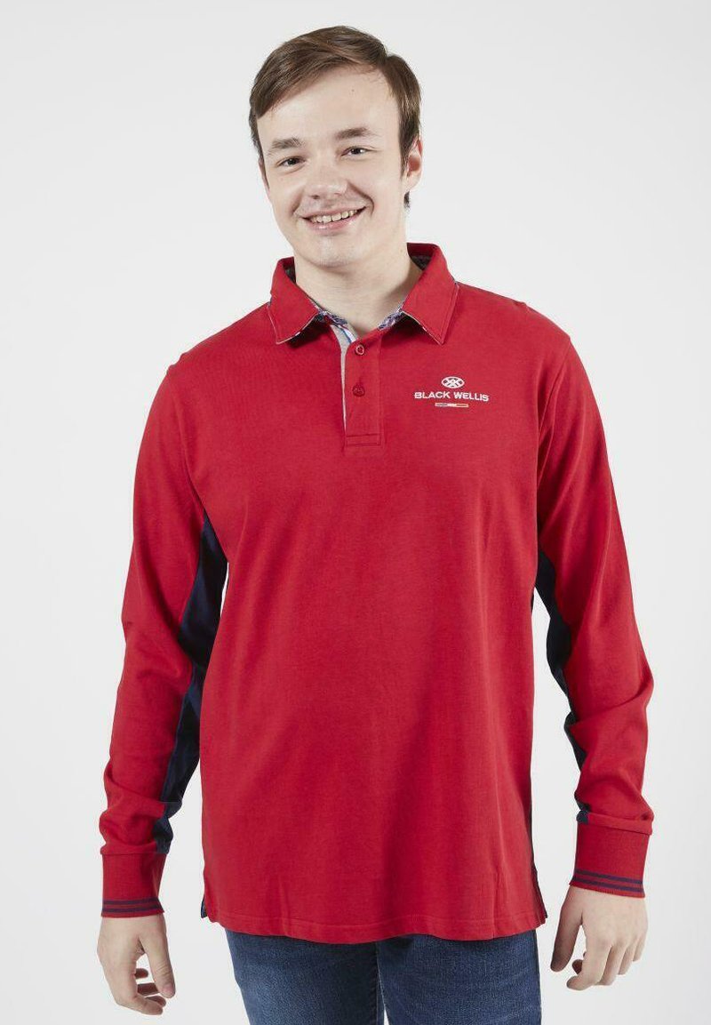 Polo à manches longues en coton rouge avec des panneaux latéraux et un col contrastants en marine, arborant un logo sur la poitrine.