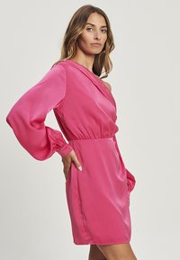 Krátke ružové saténové šaty s dlhými rukávmi, off-shoulder strihom a priliehavým pásom. Hladká textúra s minimalistickým štýlom.