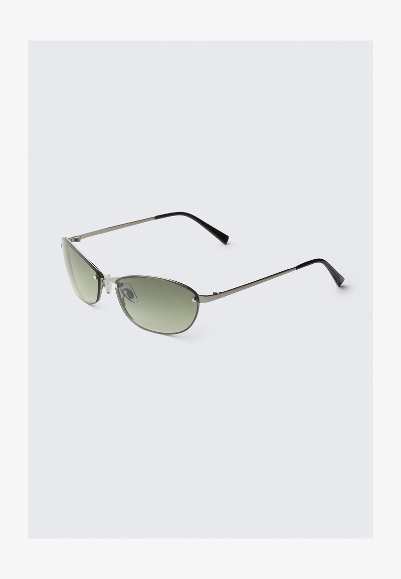 Metalliset aurinkolasit, joissa on pitkänomaiset vihreät linssit, kapea hopeakehys ja mustat templetipit. Varustettu pienillä nenätukilla mukavuutta varten.