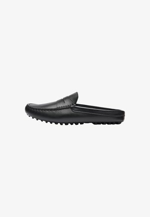Chaussure slip-on en cuir noir avec un bout arrondi, des coutures décoratives, et une semelle en caoutchouc texturée dotée de petites languettes de traction.