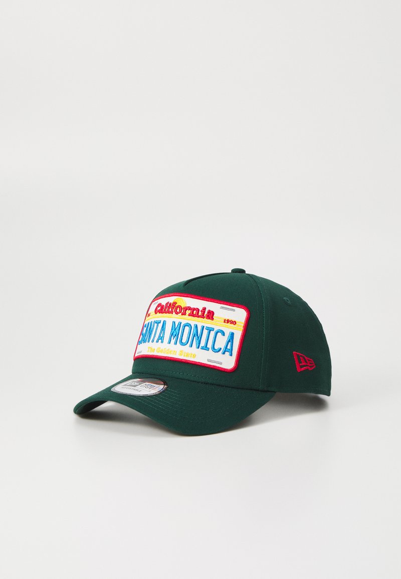 Căciulă de baseball verde cu margine plată, având un patch brodat colorat care scrie "California 1990 SANTA MONICA" și accente roșii.