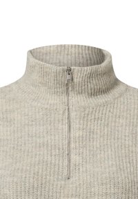 Pull gris clair à côtes avec un col montant et une fermeture éclair mi-longueur. Le tissu présente une texture douce avec des variations subtiles de couleur.