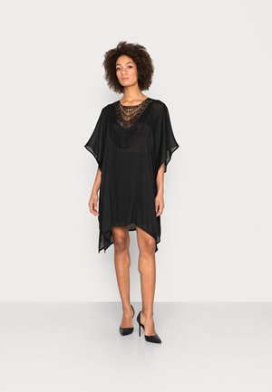 Čierny kaftan s voľným dizajnom, ktorý má textúrovaný, zdobený výstrih. Ľahká, polopriehľadná tkanina s krátkymi rukávmi.