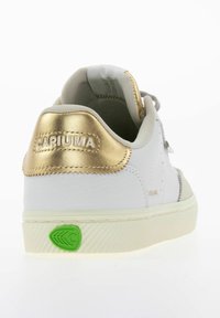 Białe sneakersy z teksturowanym wykończeniem, złotą pętelką na pięcie, szarymi akcentami i zielonym logo na podeszwie. Posiadają okrągłe sznurowadła.