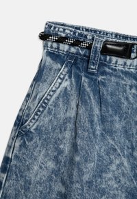 Džínové kalhoty s vysokým pasem, acid-wash modré s skladováním, bočními kapsami, poutky na opasek a černo-bílým pleteným opaskem.