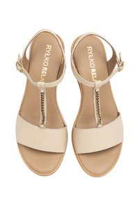 Beżowe skórzane sandały z designem T-paska, z cienkim łańcuszkiem akcentującym i zapięciem na kostce, oraz z teksturowaną wyściółką.