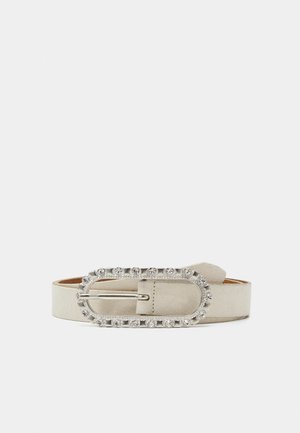 Ceinture en suedé beige avec un design large et une boucle ovale décorative en argent ornée de strass sur les bords.