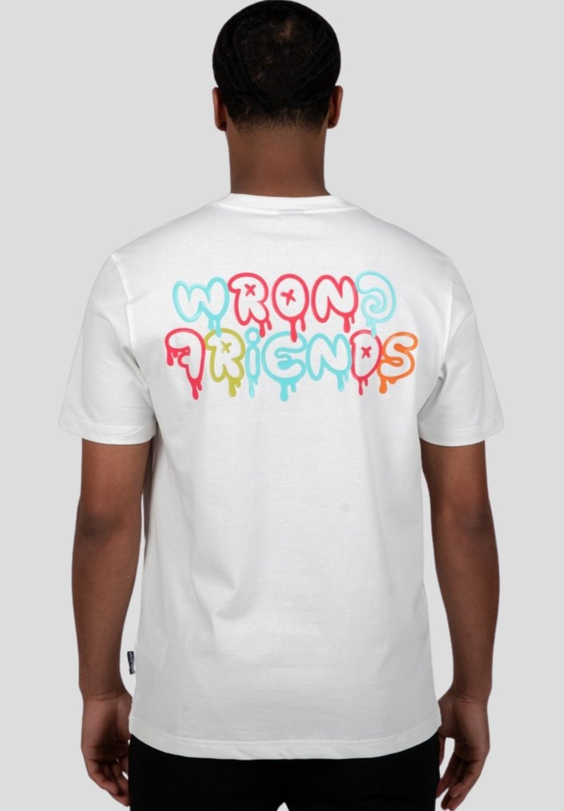 Camiseta de algodón blanca con el texto colorido "WRONG FRIENDS" goteando en rosa, azul, amarillo y naranja en la parte posterior. Mangas cortas.