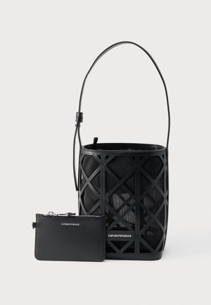 Črna torbica v obliki vedra z geometričnim izreznim vzorcem in ujemajočo se majhno torbico z zadrgo, obe z znamko Emporio Armani.
