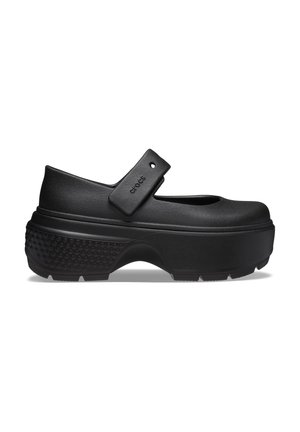 Schwarzer Mary-Jane-Schuh mit Plattform, strukturierter Sohle, rundem Zehenbereich und verstellbarem Riemen mit der Aufschrift "Crocs" über dem Spann.