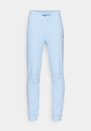 Joggers de algodón azul claro con cintura elástica y cordón, bolsillo laterales y pu�ños acanalados. Presenta un pequeño logo en la parte superior de la pierna.
