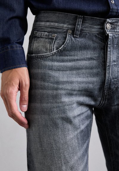 Jeans in denim grigio con una forma aderente, caratterizzati da un design di tasche classico, rivetti metallici e dettagli di sfumatura leggeri. Tessuto testurizzato.