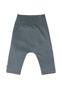 Miękkie, lekkie szare spodnie dziecięce z szerokim elastycznym pasem, szerokimi nogawkami i metką z boku. Gładka tekstura materiału.