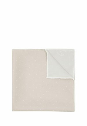 Coperta di cotone beige chiaro con pois bianchi e un bordo testurizzato bianco, con una piega all'angolo che mostra un tessuto liscio e uniforme.