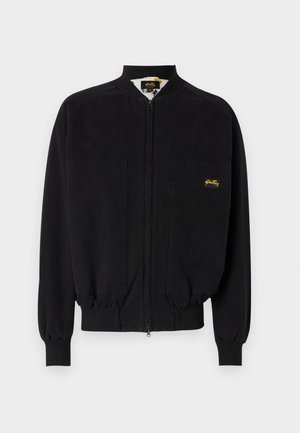 Black zip-up jacket made of smooth fabric, featuring a band collar, two front pockets, ribbed cuffs, and a small logo on the left chest.