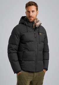 Padded zwarte pufferjack met een capuchon, met een faux fur voering en een ritssluiting aan de voorkant, gedetailleerd met gele branding en ritszakken.