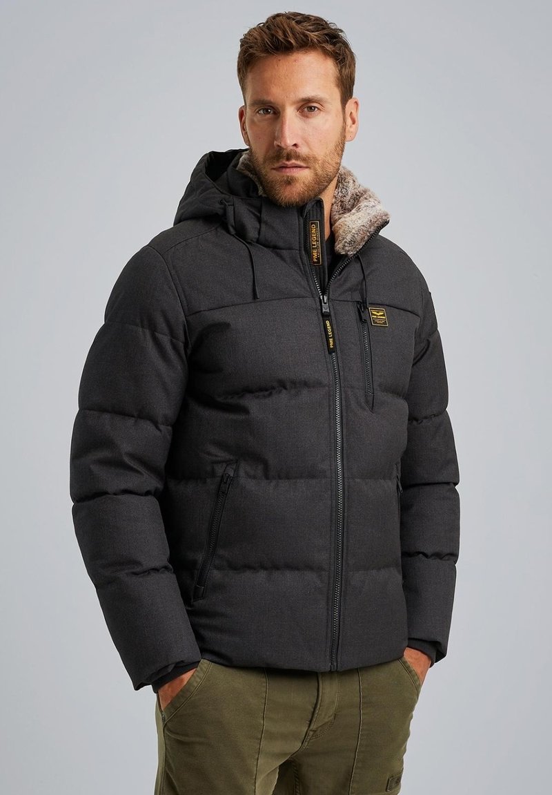 Padded zwarte pufferjack met een capuchon, met een faux fur voering en een ritssluiting aan de voorkant, gedetailleerd met gele branding en ritszakken.
