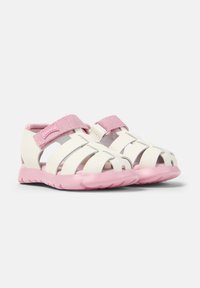 White rubber sandals with pink soles and straps. Open design with multiple cutouts and a hook-and-loop closure for adjustable fit.