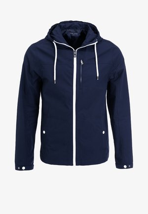 Veste imperméable navy avec capuche, zips blancs et cordons de serrage. Comprend une poche frontale zippée et deux poches latérales à pression. Texture lisse.
