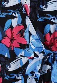 Tissu floral présentant de grandes fleurs roses et bleues sur un fond noir. Texture lisse avec un design portefeuille et un accent de ceinture.