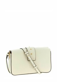 Piccola borsa a tracolla in pelle color crema con tracolla regolabile e dettagli a borchie color oro sulla patta frontale.