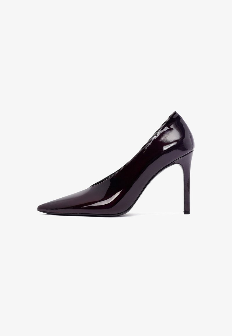 Paarse patent leren hoge hak pump met een spitse neus en een slanke silhoeët. Beschikt over een 12,7 cm hoge stiletto hak en een glad, glanzend oppervlak.
