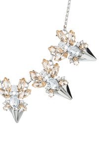 Collier en argent avec trois grappes de cristaux clairs et champagne en forme de marquise et ronds, chacune ornée d'un pendentif en pointe argentée.