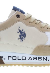 Béžové tenisky s komponenty z semišu a kůže, vyšívaným logem hráče póla a černým textem "U.S. POLO ASSN." na podrážce.