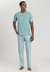 T-shirt in cotone azzurro chiaro con maniche corte, abbinato a pantaloni da pigiama con un motivo geometrico in turchese e bianco.