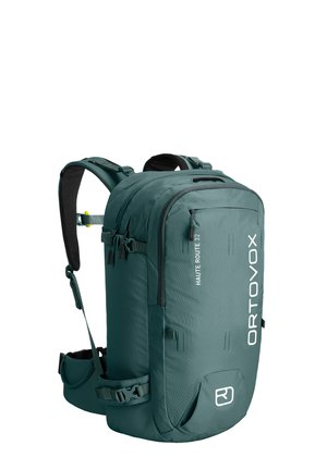 Green Ortovox Haute Route 32 hiking backpack with padded shoulder straps, hip belt, multiple zippered compartments, and compression straps.